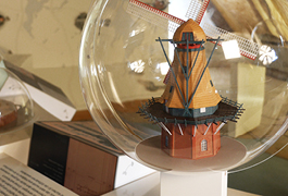 Detailed view of an exhibit. A miniature representation of a windmill is enclosed in a transparent sphere.