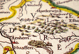 Photo showing details of a historical map of Holland in the 17th century. The coloured image of the topography is complemented by a transparent description in Braille applied to the map.