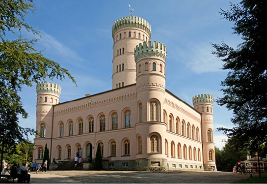 Photo with exterior view of the Granitz hunting lodge, built in 1846 by the Putbus family. It is built in the style of northern Italian Renaissance castels with four corner towers and an imposing central tower.
