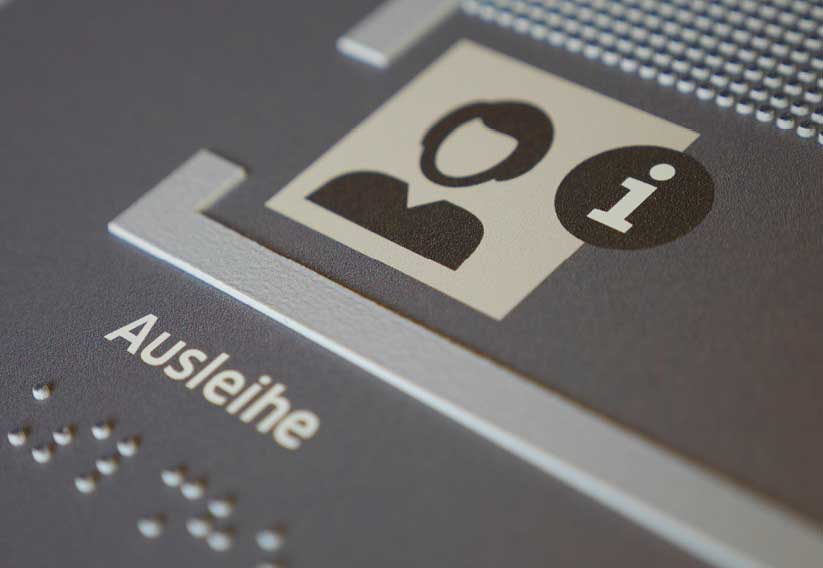Close-up of a tactile plan; here the word "Ausleihe" in black and braille as well as tactile lines and areas.