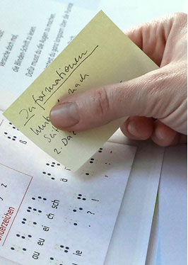 Close-up of a hand sticking a correction note into the boo