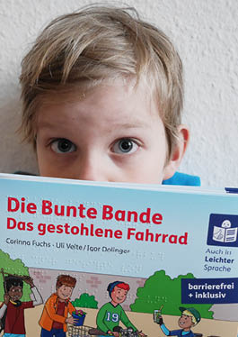 Ein Junge schaut mit großen Augen über den oberen Rand des Buches.