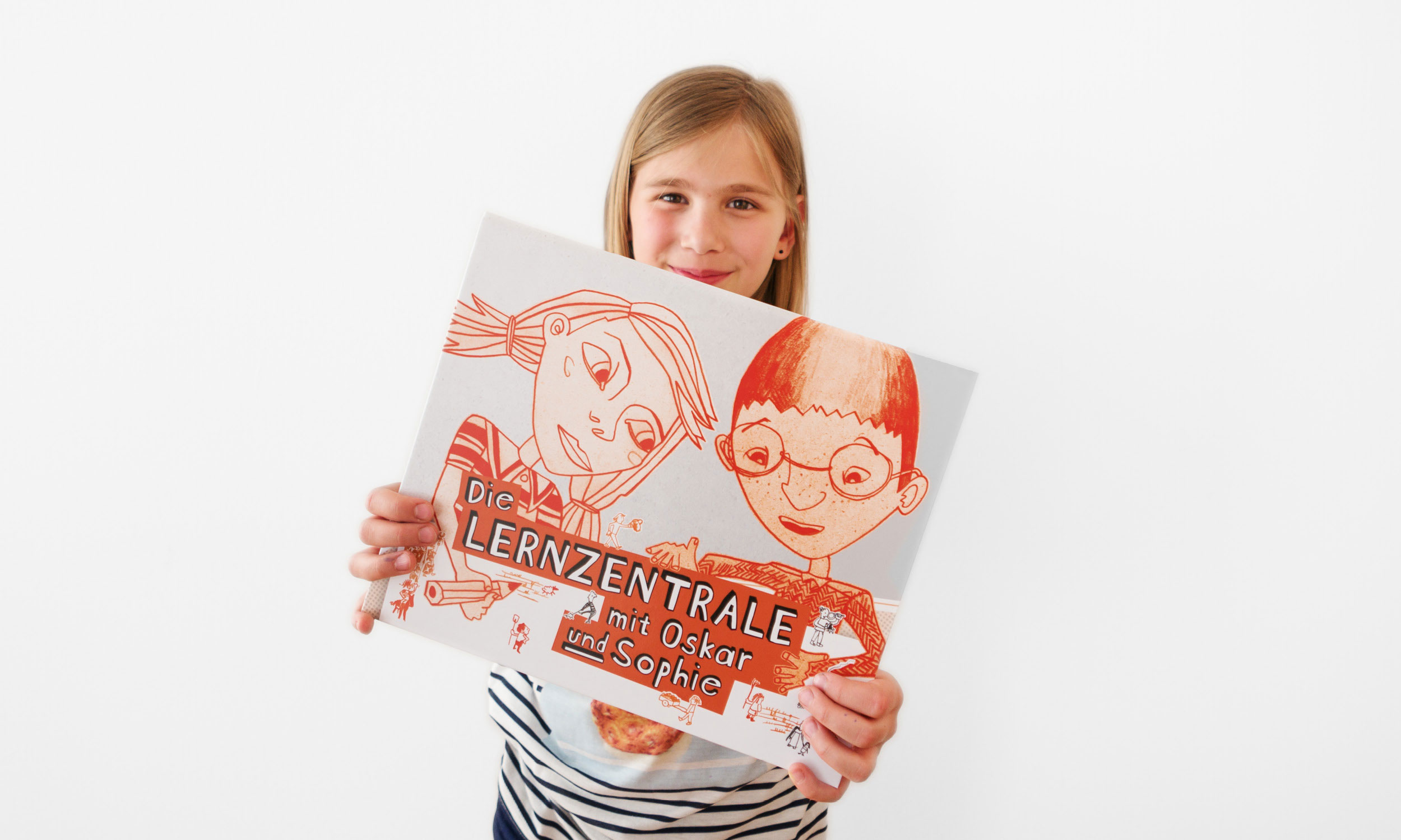 Photo of a smiling girl proudly showing the folder "The Learning Centre with Oskar and Sophie".