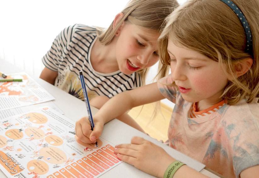 Foto zweier Mädchen beim Ausfüllen des Lernmaterials