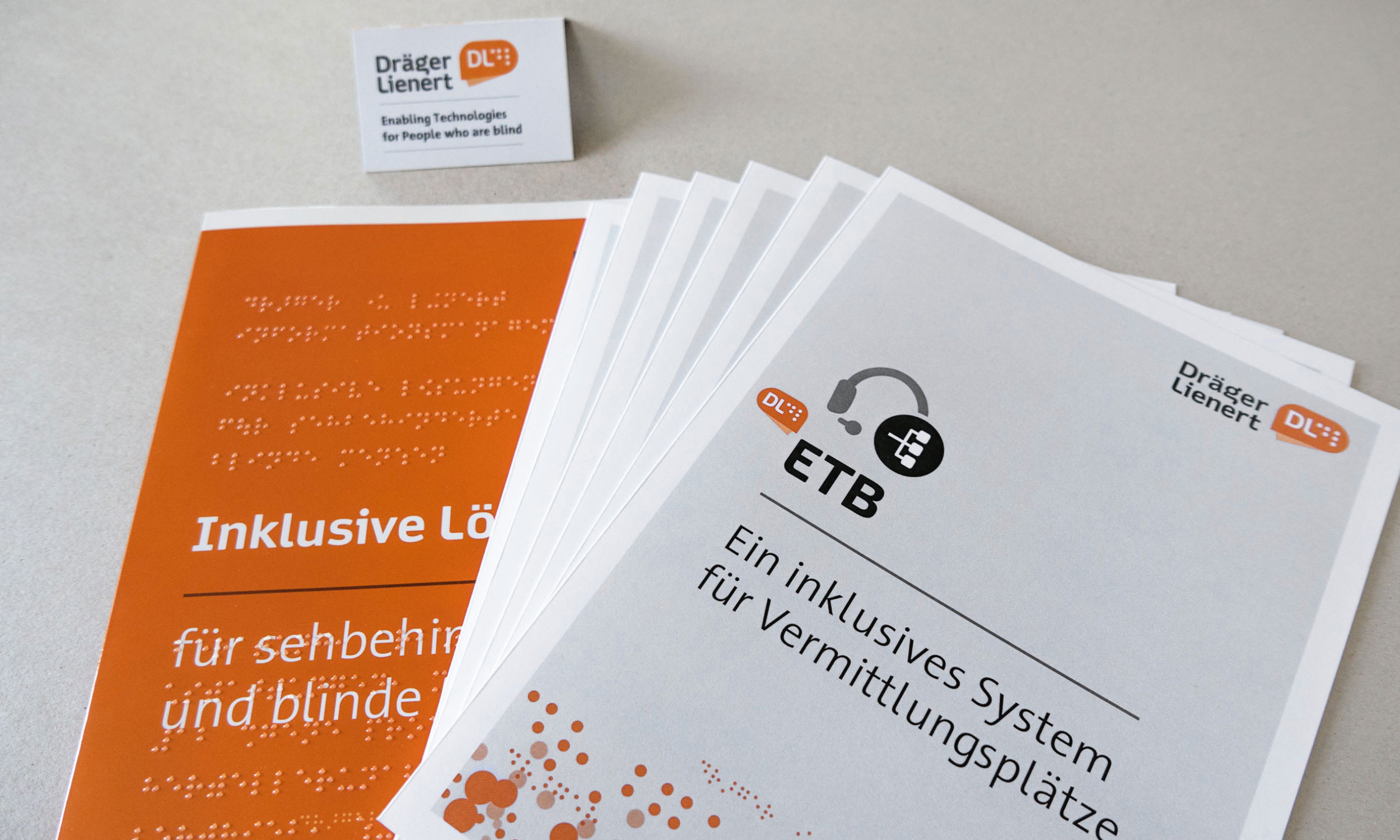 Detail photo of leaflet titles with logo of the company and a business card.