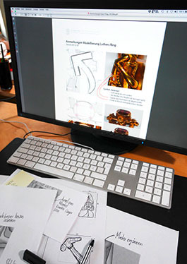Photo with a view of sketch sheets and a screen with digitised designs for the implementation of the wedding ring as button elements