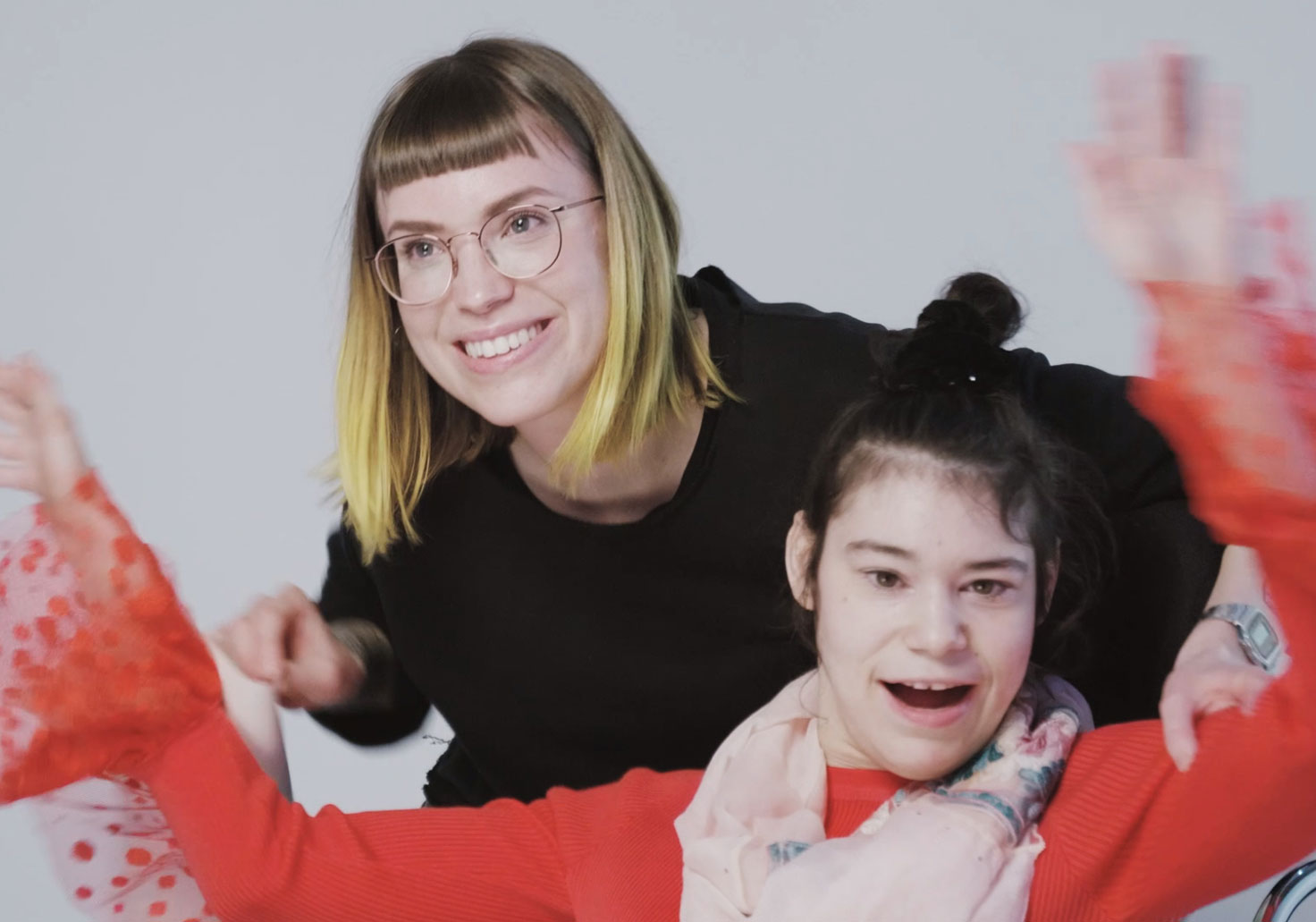 Photo of an enormously happy, severely disabled young woman in a wheelchair and her carer during the photo shooting