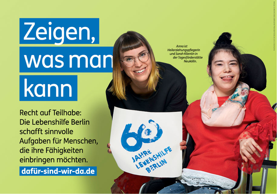 Foto des Großflächenmotivs „Zeigen, was man kann“ mit der schwerstbehinderten jungen Frau und ihrer Betreuerin und dem gestempelten Jubiläumslogo der Lebenshilfe Berlin