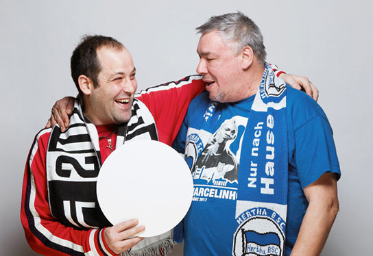 Photo of two disabled soccer fans of Hertha BSC and Juventus Turin from the same shared apartment, hugging each other amicably in the studio