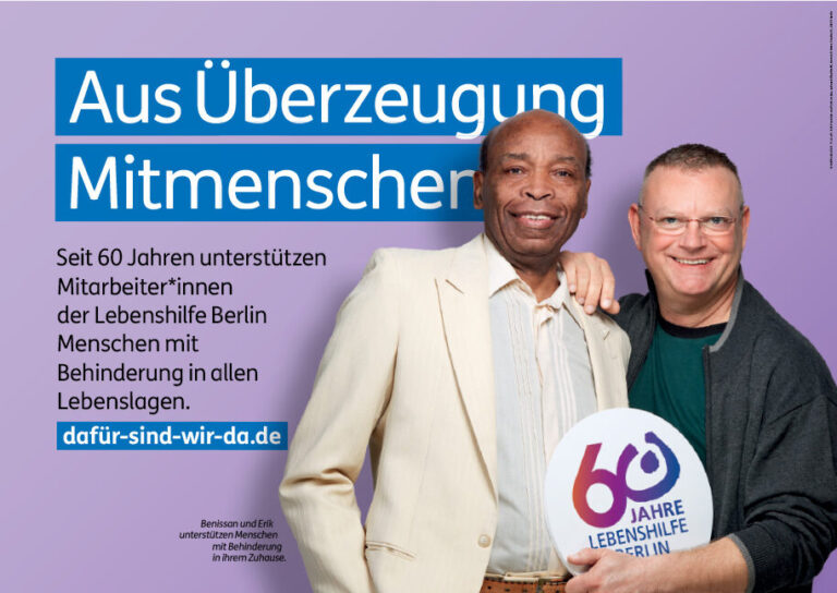 Large poster of the motif „By conviction fellow human beings“ which shows two caretakers from Lebenshilfe Berlin, including one who comes from Togo.