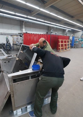 Two employees assembling the folding mechanism of the touch model