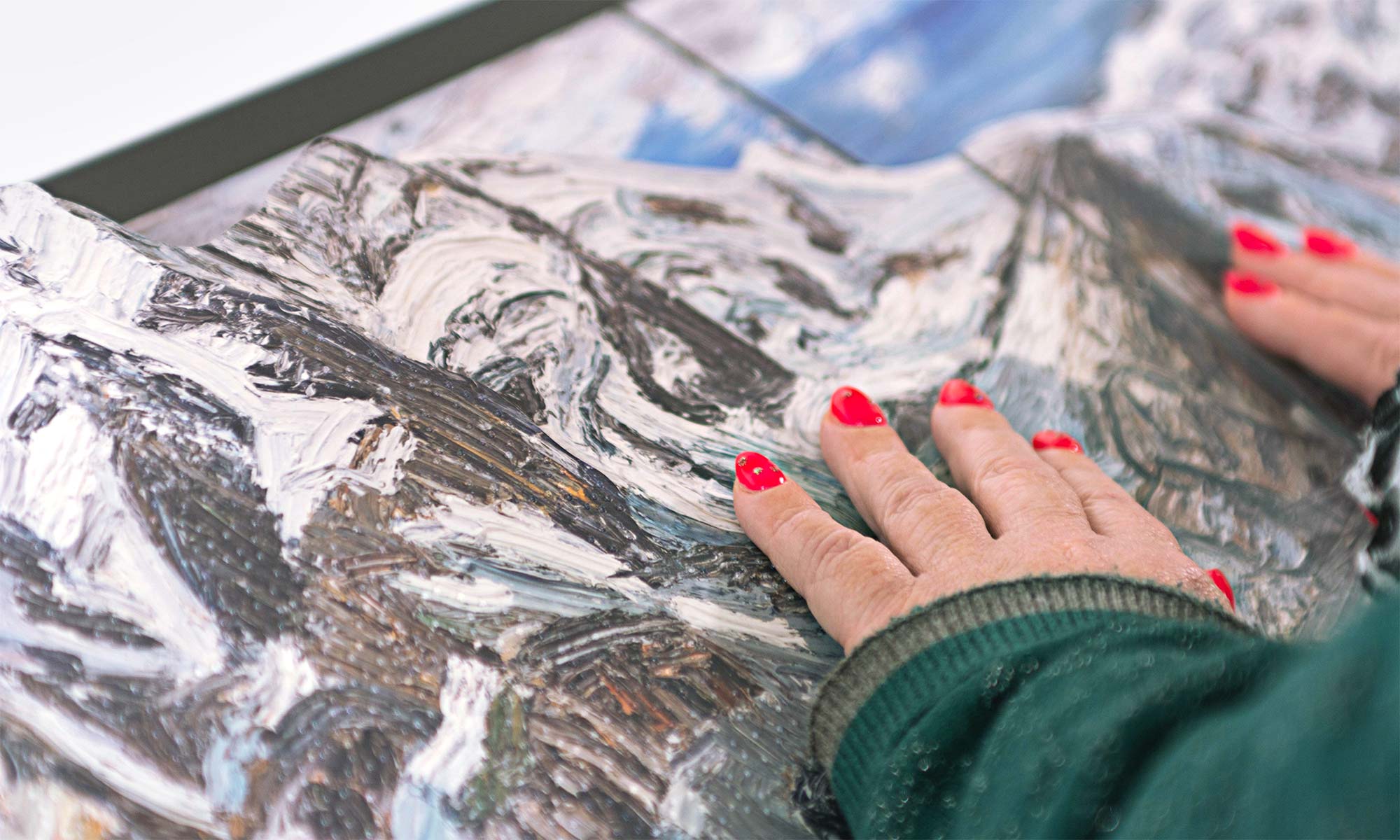 Detailfoto des Tastmodells „Bergwelten“ welches von einer Frau mit beiden Händen ertastet wird.
