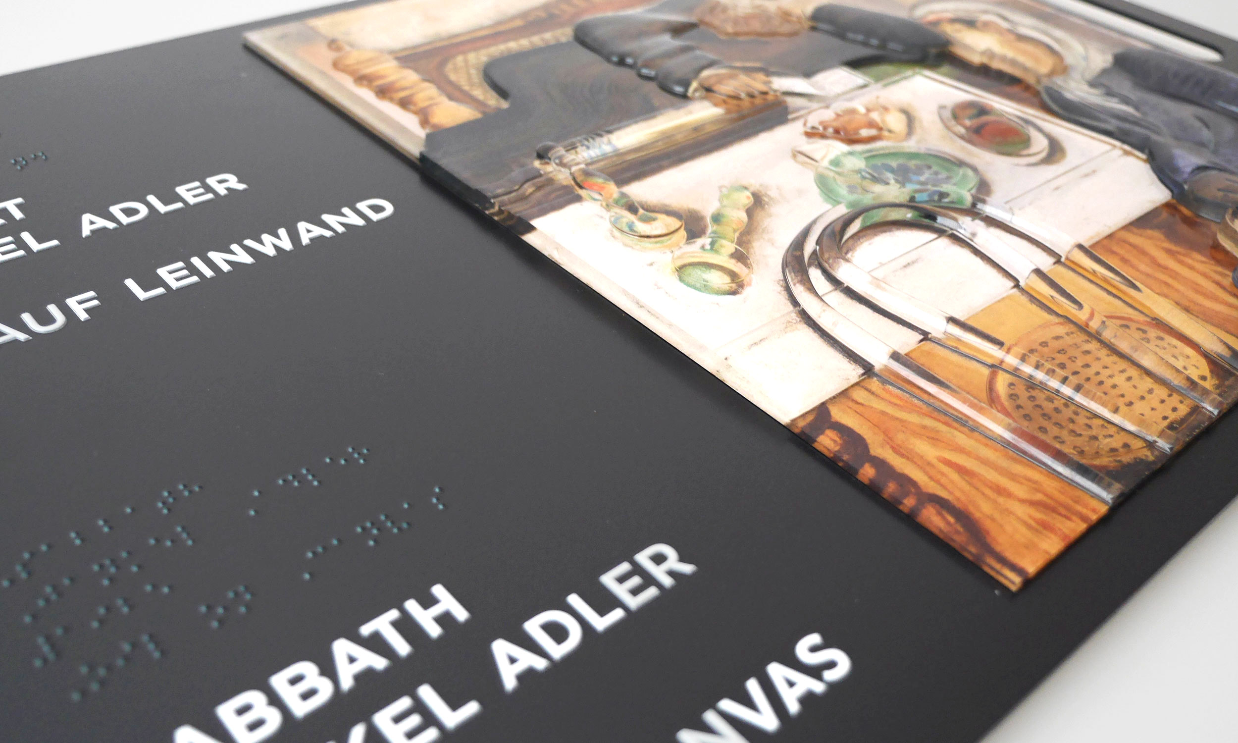 Detailfoto vom Tastmodell des Gemäldes „Sabbat“ von Janker Adler. Zu sehen sind Teile der rechten Hälfte des Tastplans mit dem Kunstwerk in Acryl, sowie Teile der linken Hälfte mit Beschreibung in Profilschrift und in Braille.