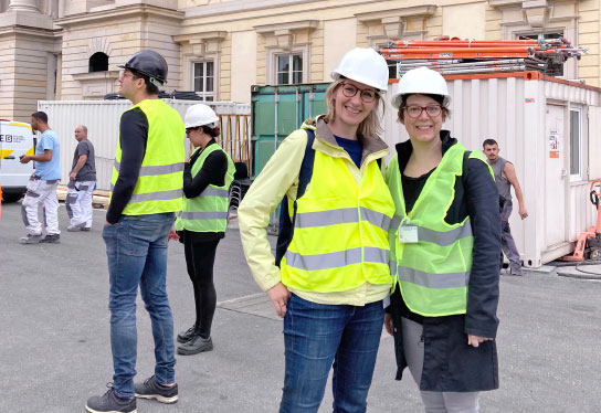 Two employees of incl. Design in neon green vests are on the construction site in front of the Humboldt Forum.